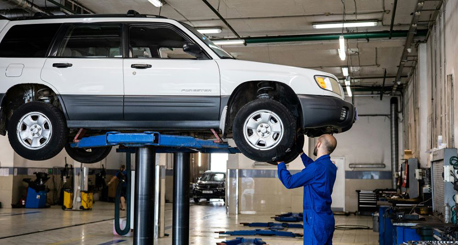 A man inspecting a car avoiding common brake maintenance mistakes
