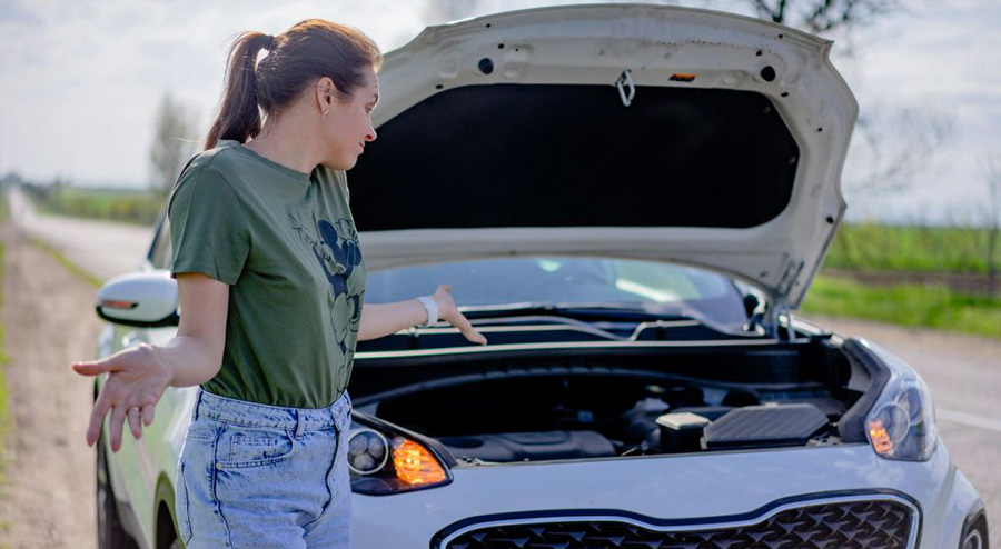 A woman looking at her car wondering about quick diagnostics for a vehicle