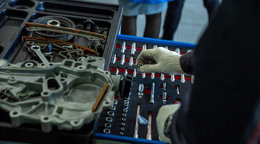 Mechanic organizing engine components in the workshop