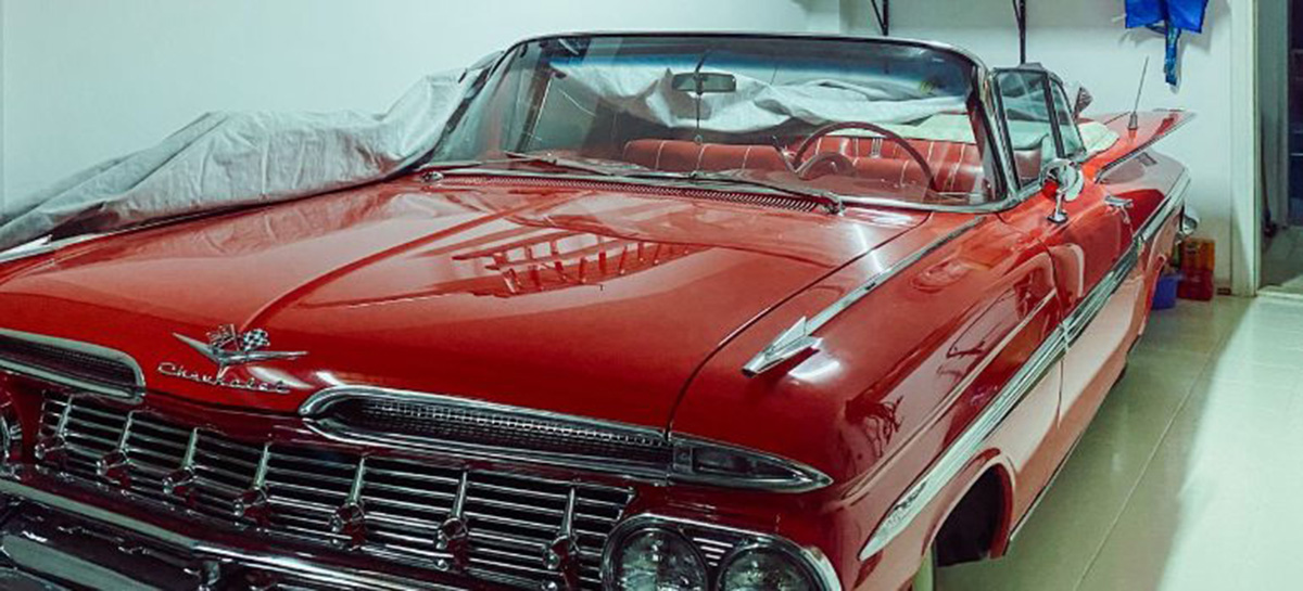 Vintage red Chevrolet Impala parked like a project-car time capsules in a storage