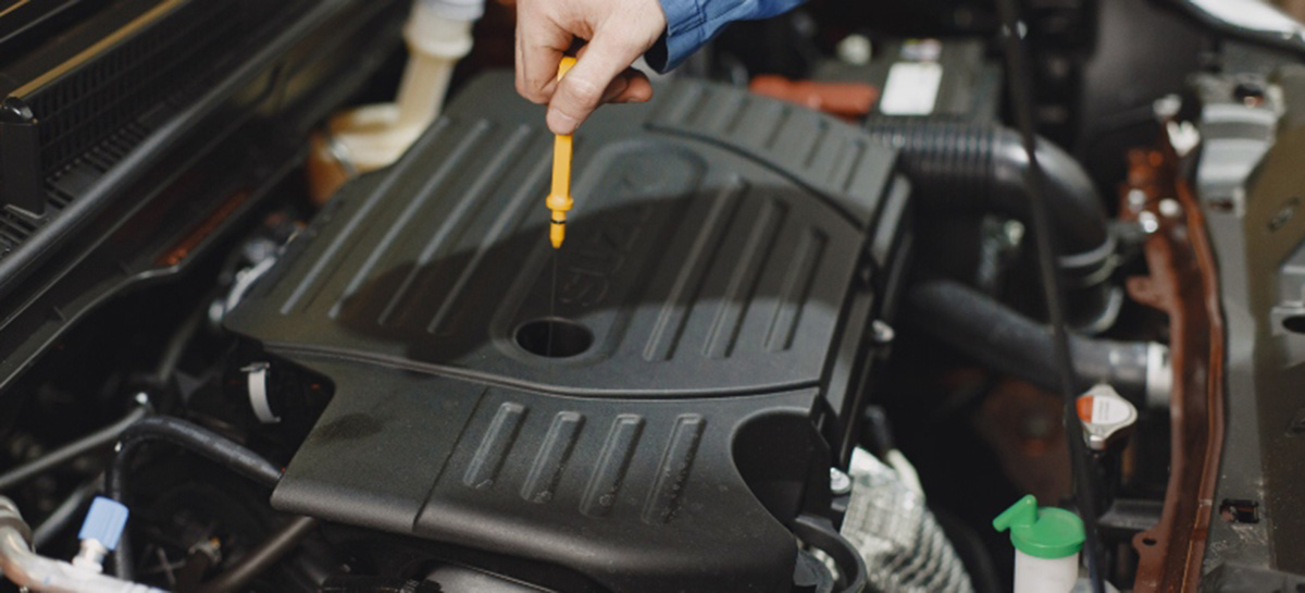 a man checking the oil on a car