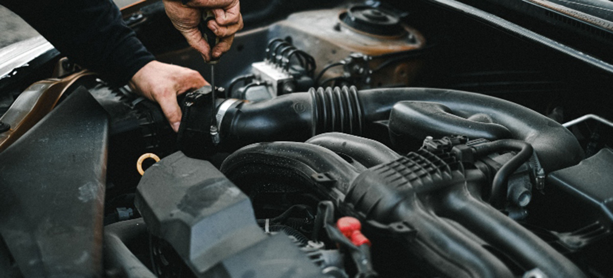 A person working with a project car getting it ready to move.